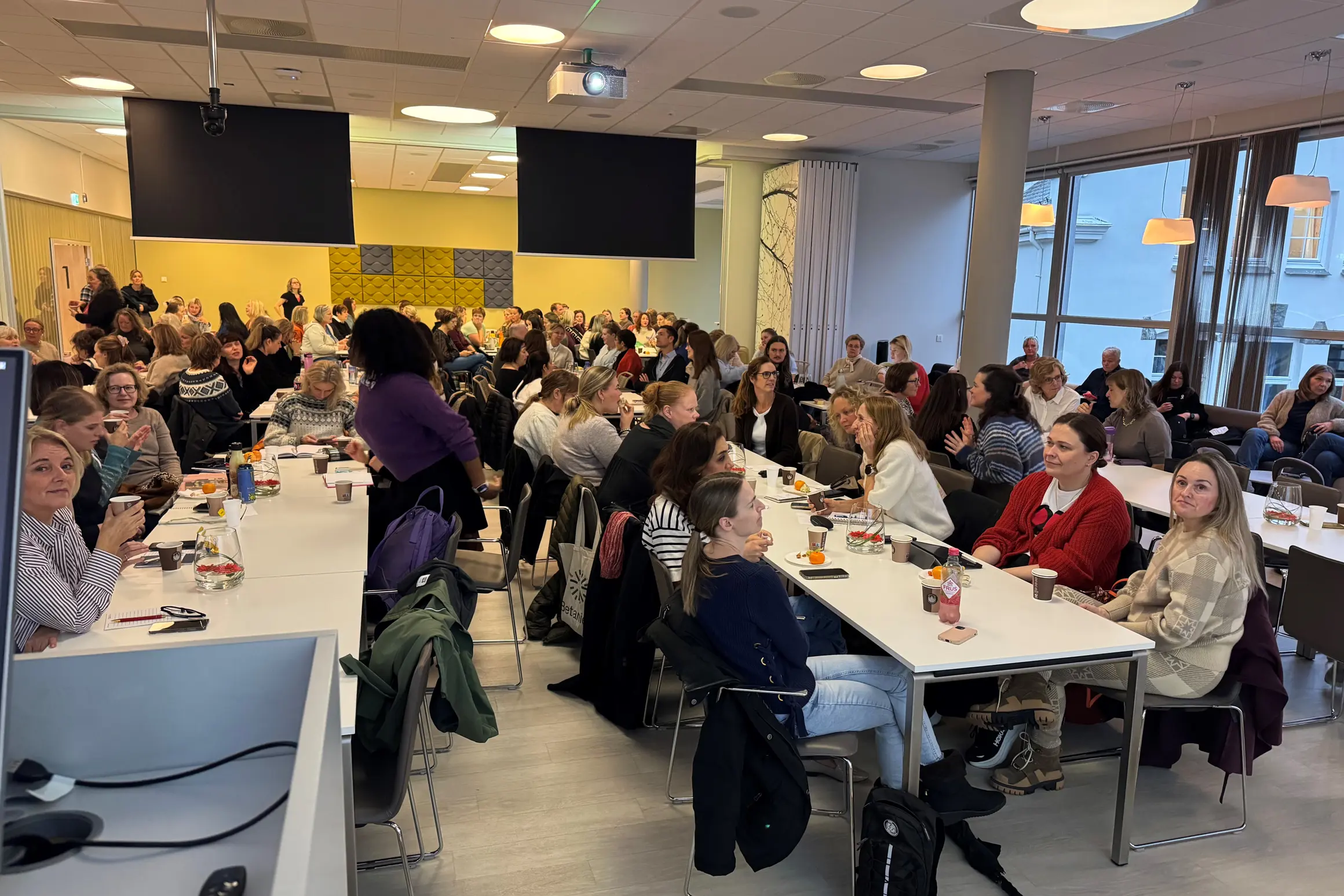 En gruppe mennesker som sitter ved bord