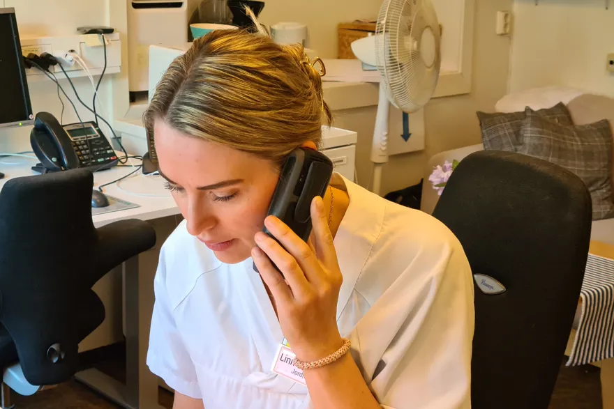 En person som holder en telefon mot øret