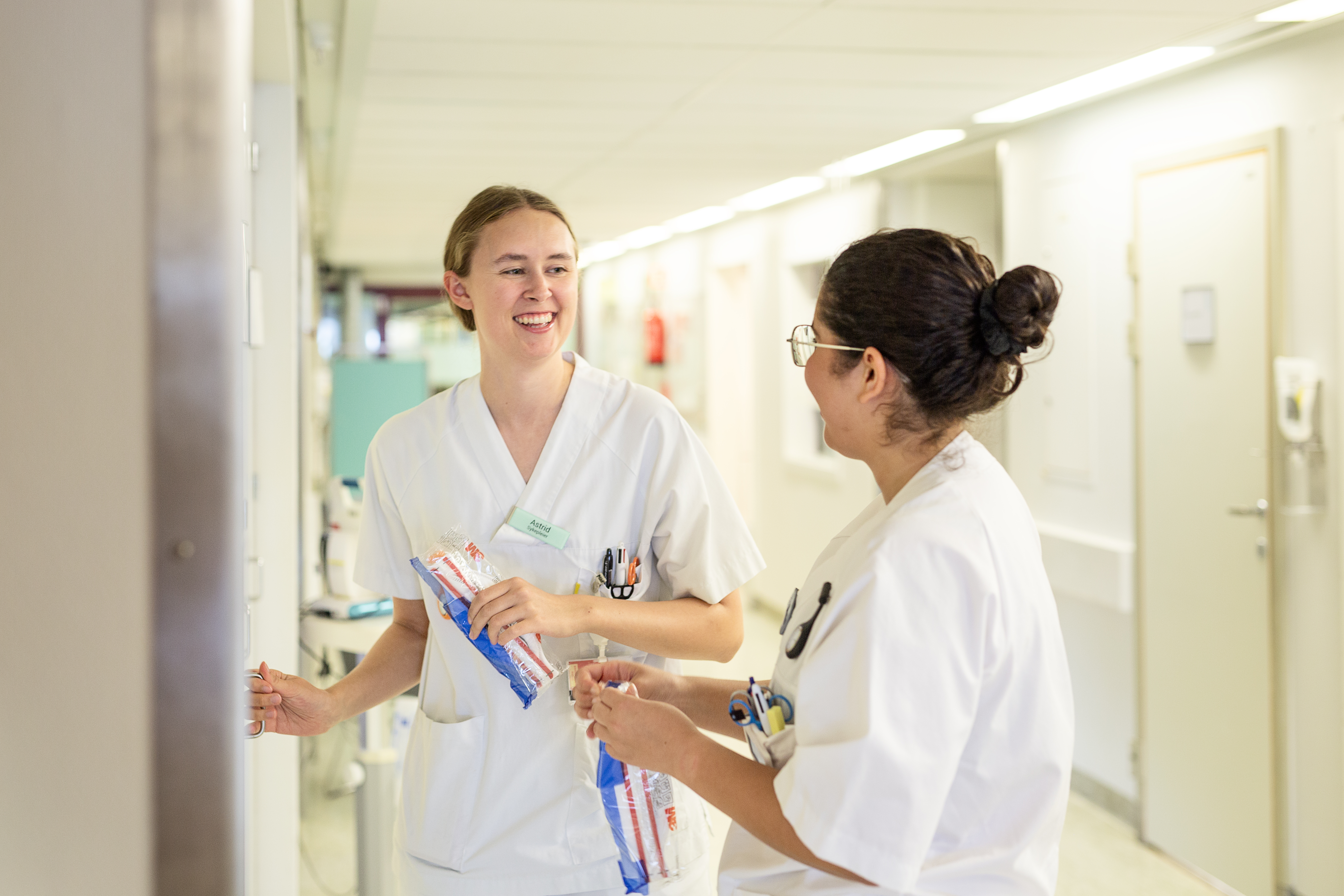 sjukepleiar på korridor, henter åndedrettsvern i skap