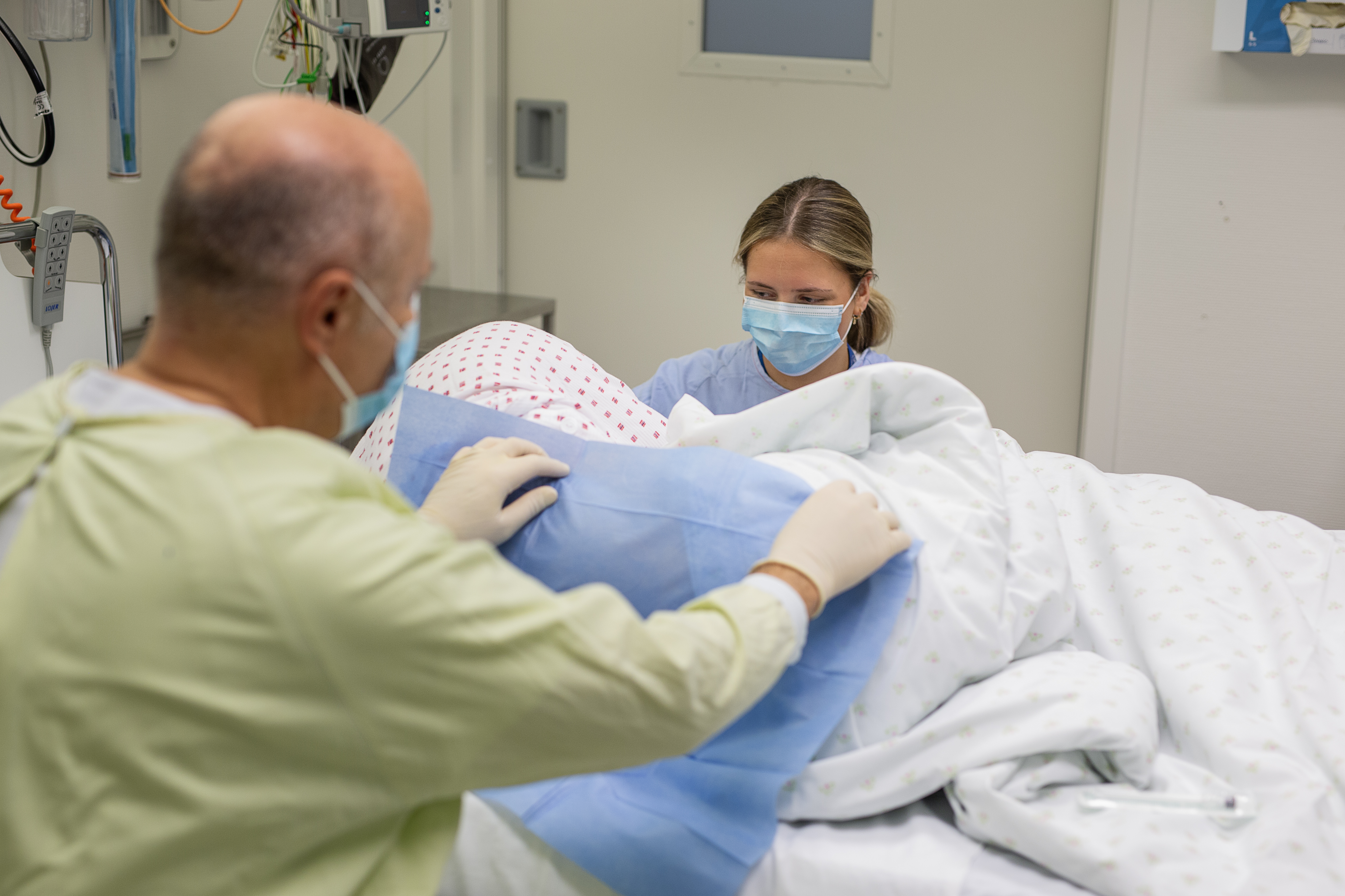 Medisisnk overvåkinseining. Lege spinalpunkterer pasient, sjukepleiar ved pasienten si side.