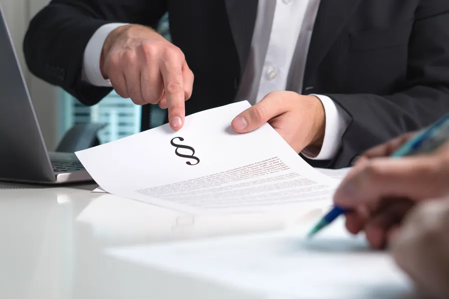 Mann peker på juridisk dokument