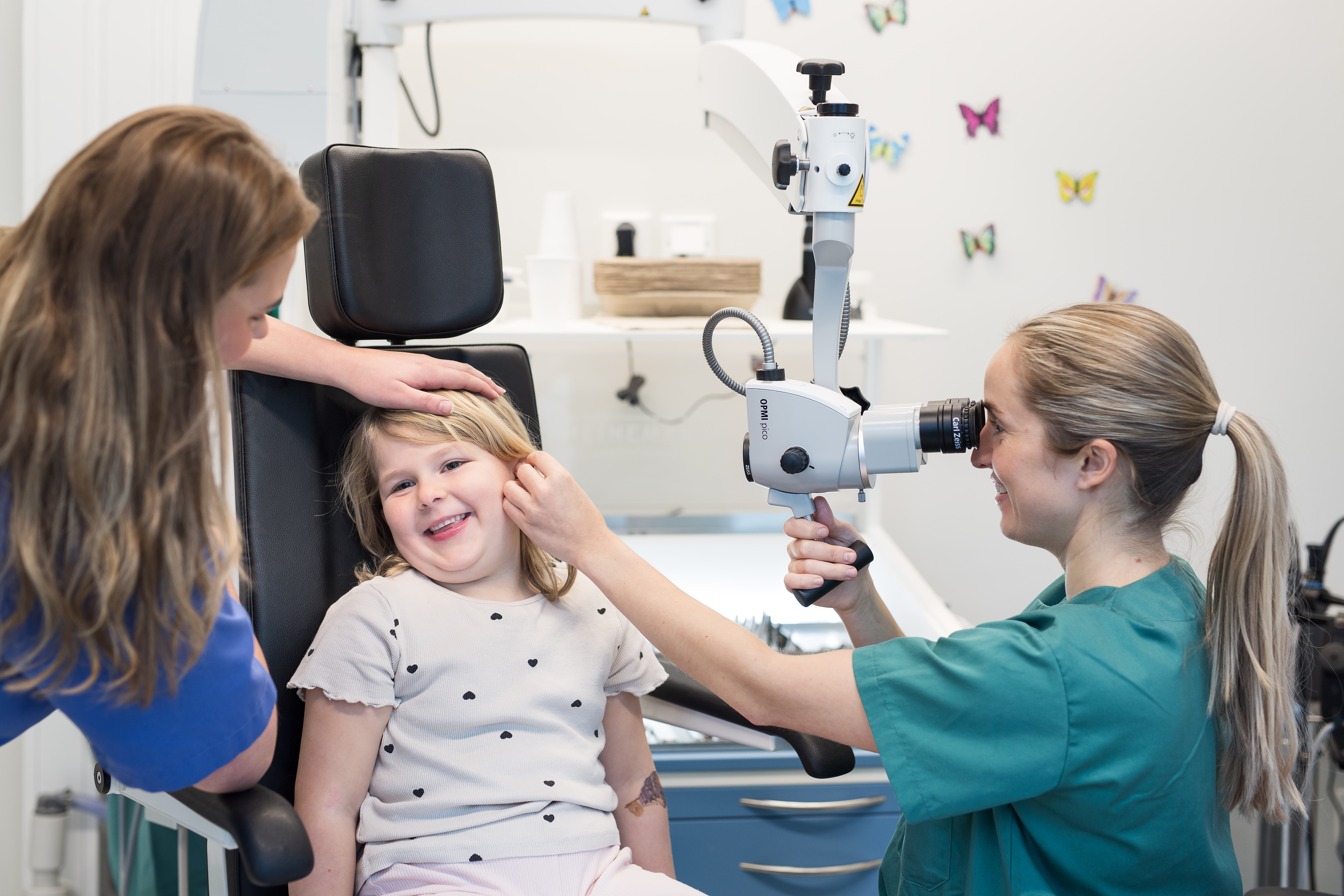 Ne jente blir undersøk i øret av en lege