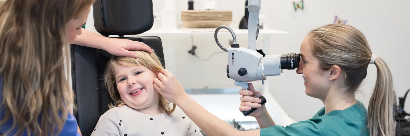 Ne jente blir undersøk i øret av en lege