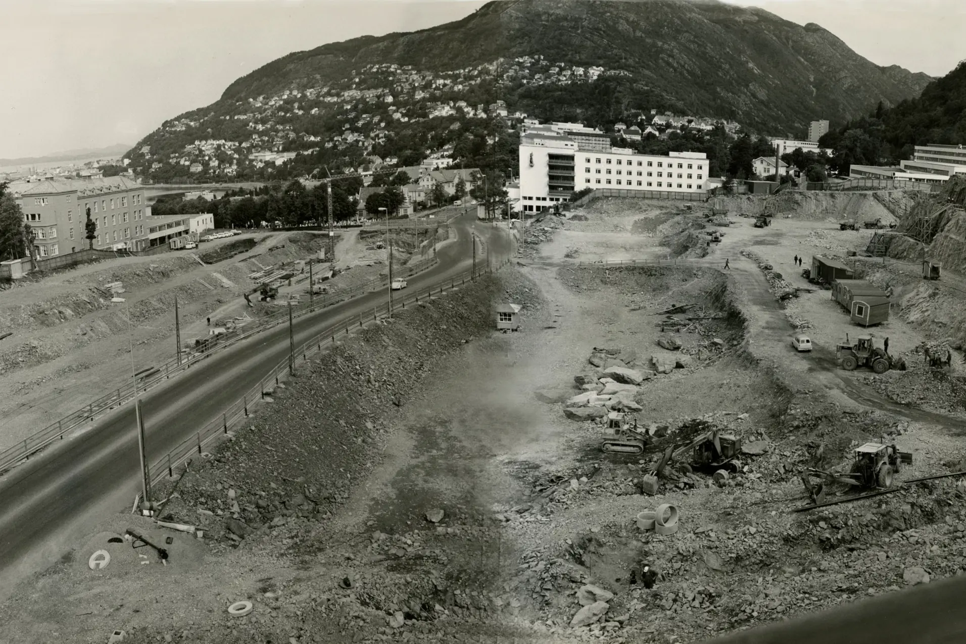 Et historisk foto av en tomt hvor det graves, med flere anleggsmaskiner