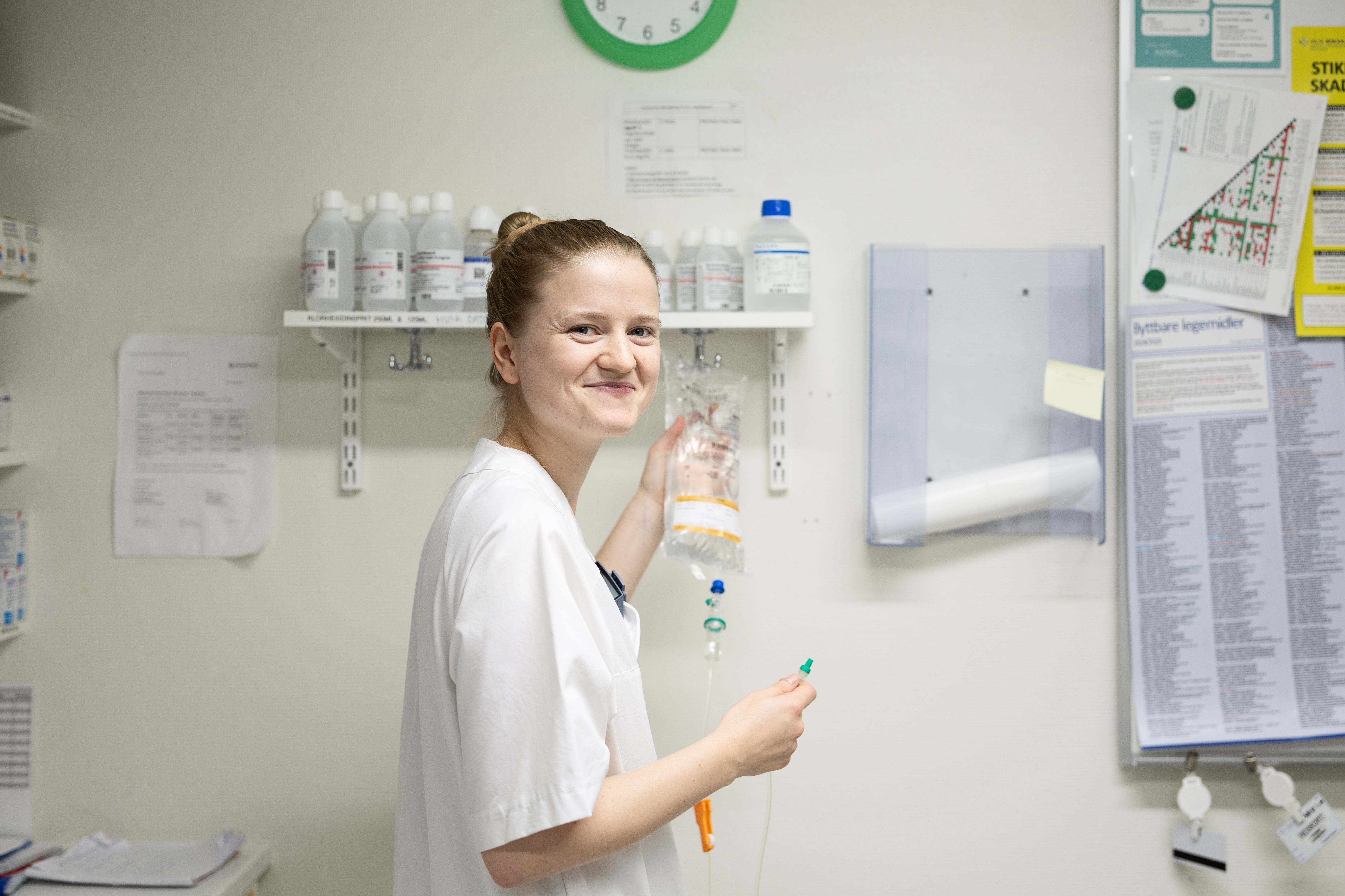 sjukepleiar gjer klar intravenøs væske på medisinrom