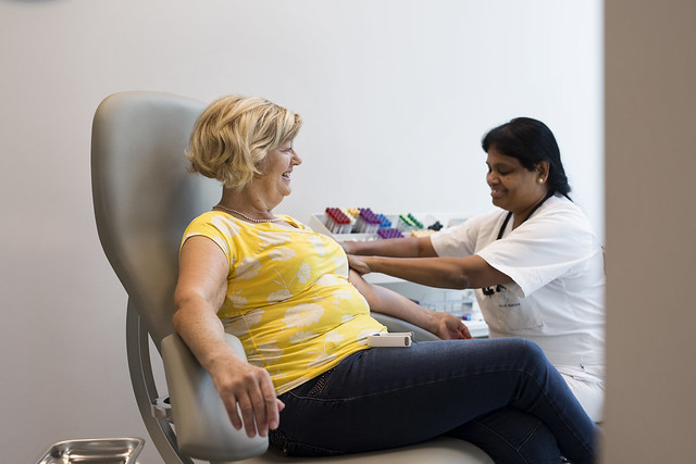 En kvinne som sitter på en stol ved siden av en kvinne som sitter på en stol