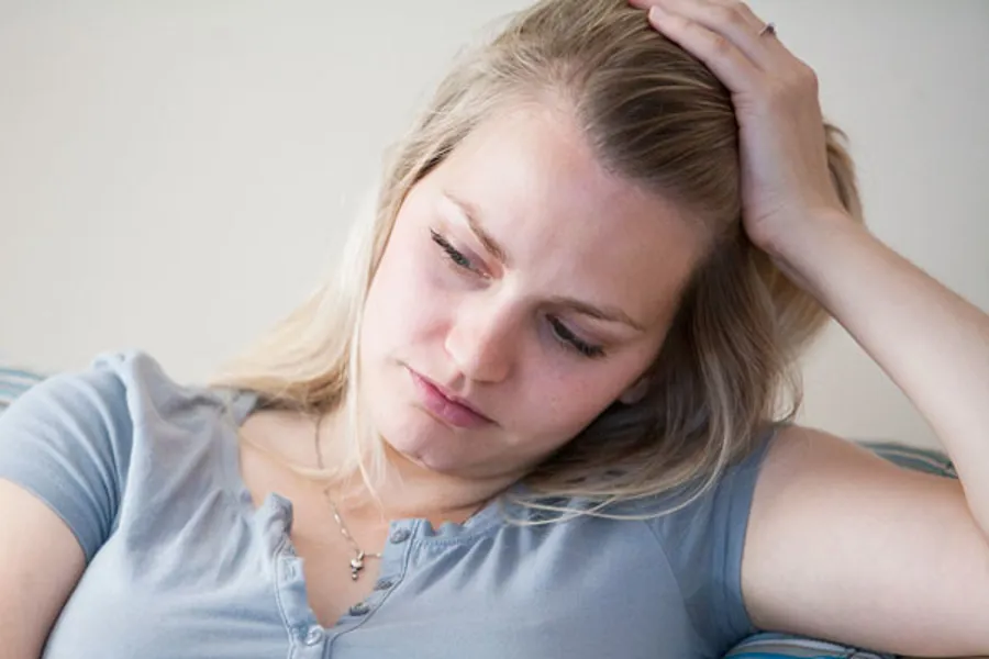 En kvinne med hodet på hånden