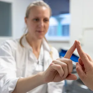 A clinical nurse testing a patient's coordination by having they pointing their finger against hers.