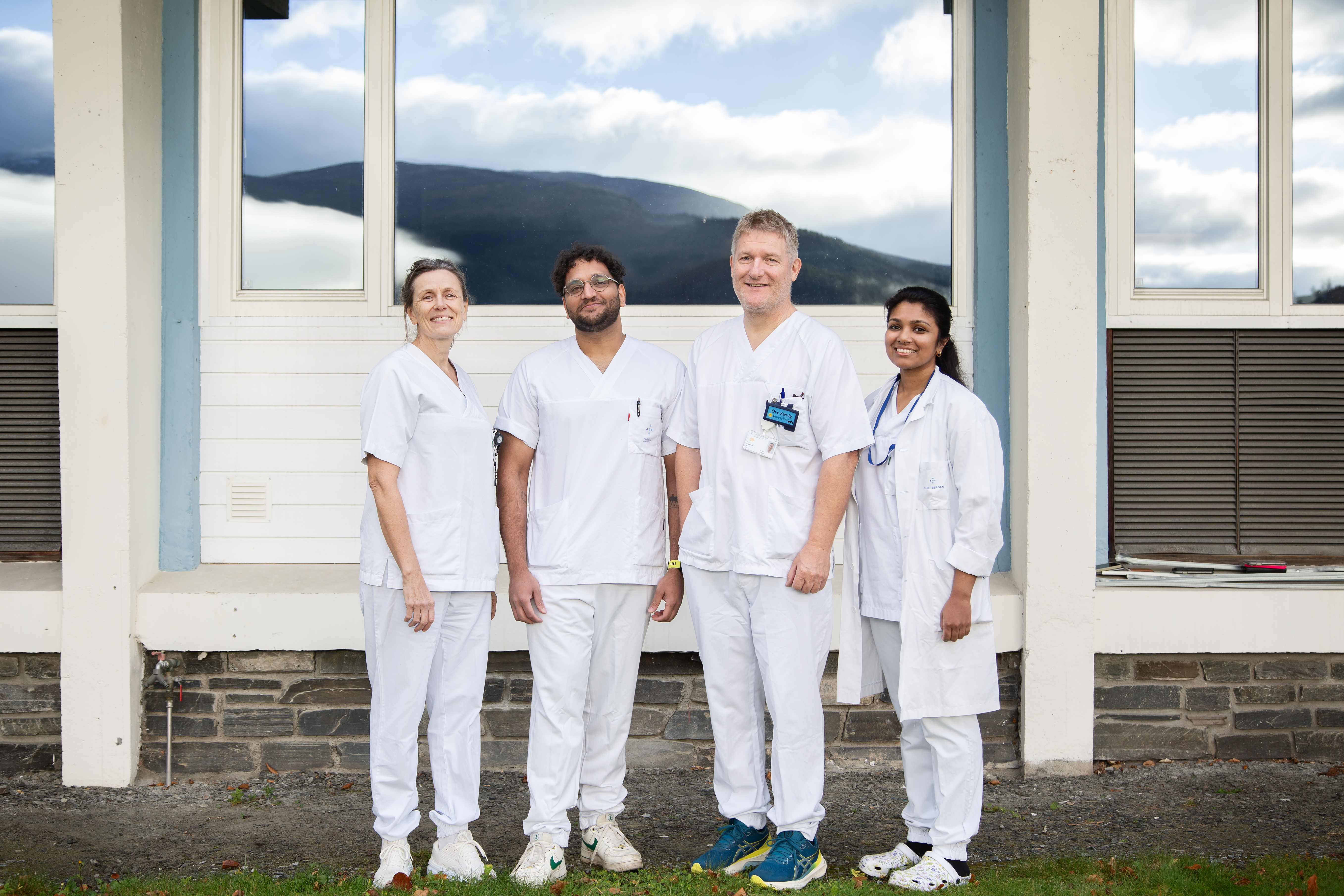 Fire kollegaer utenfor et bygg