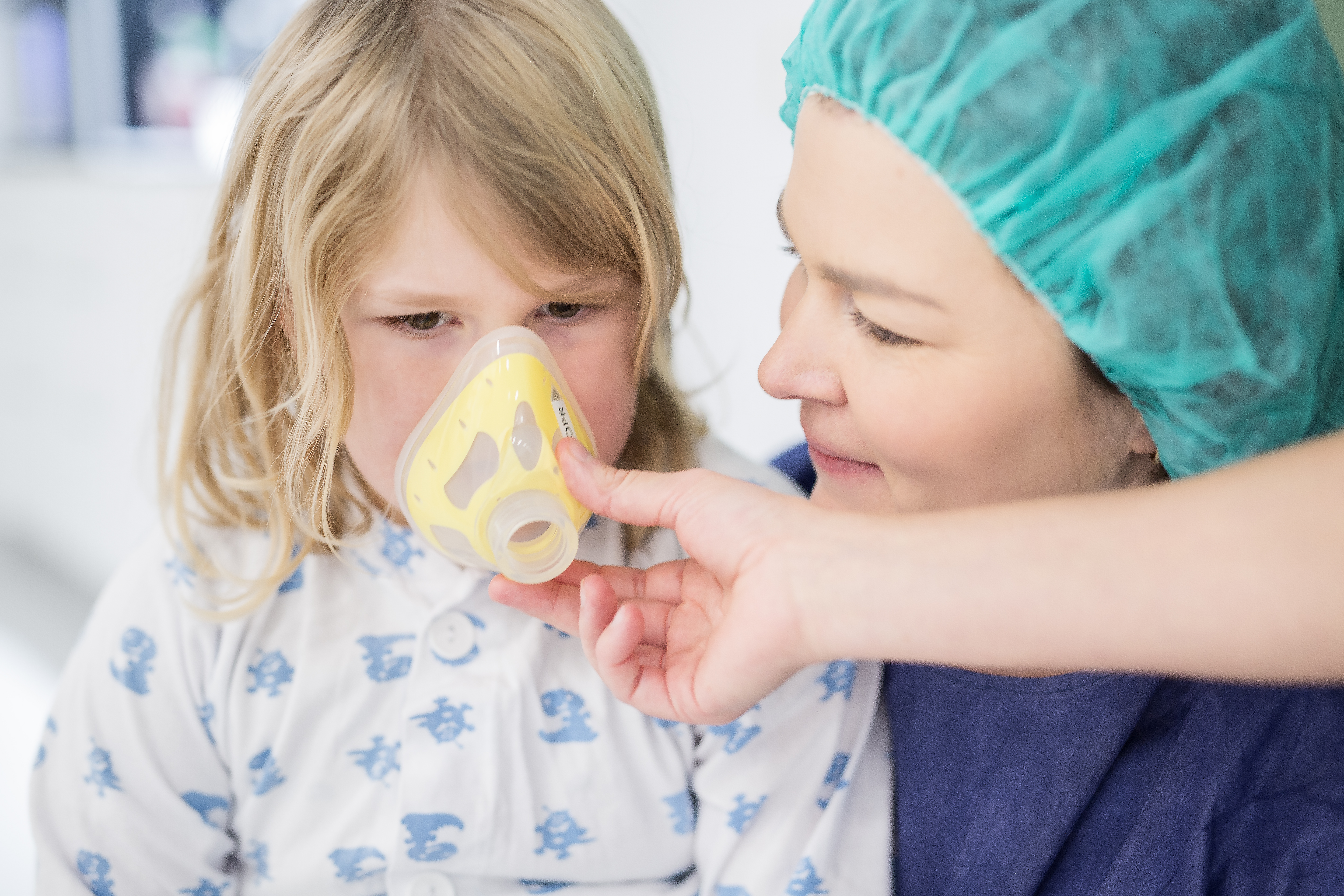 Et barn som får en maske over nese og munn