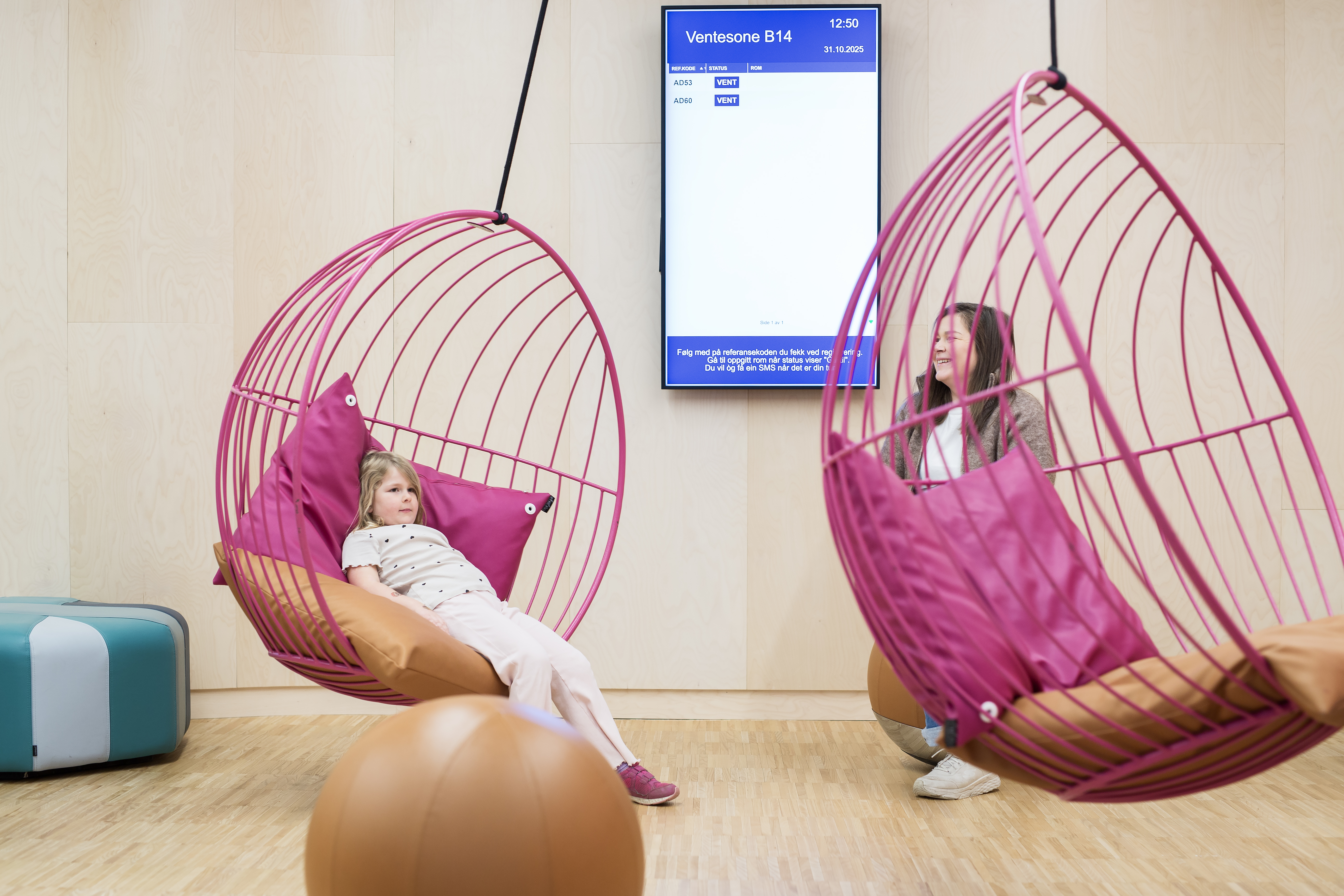 Et barn som sitter i en rosa hengestol