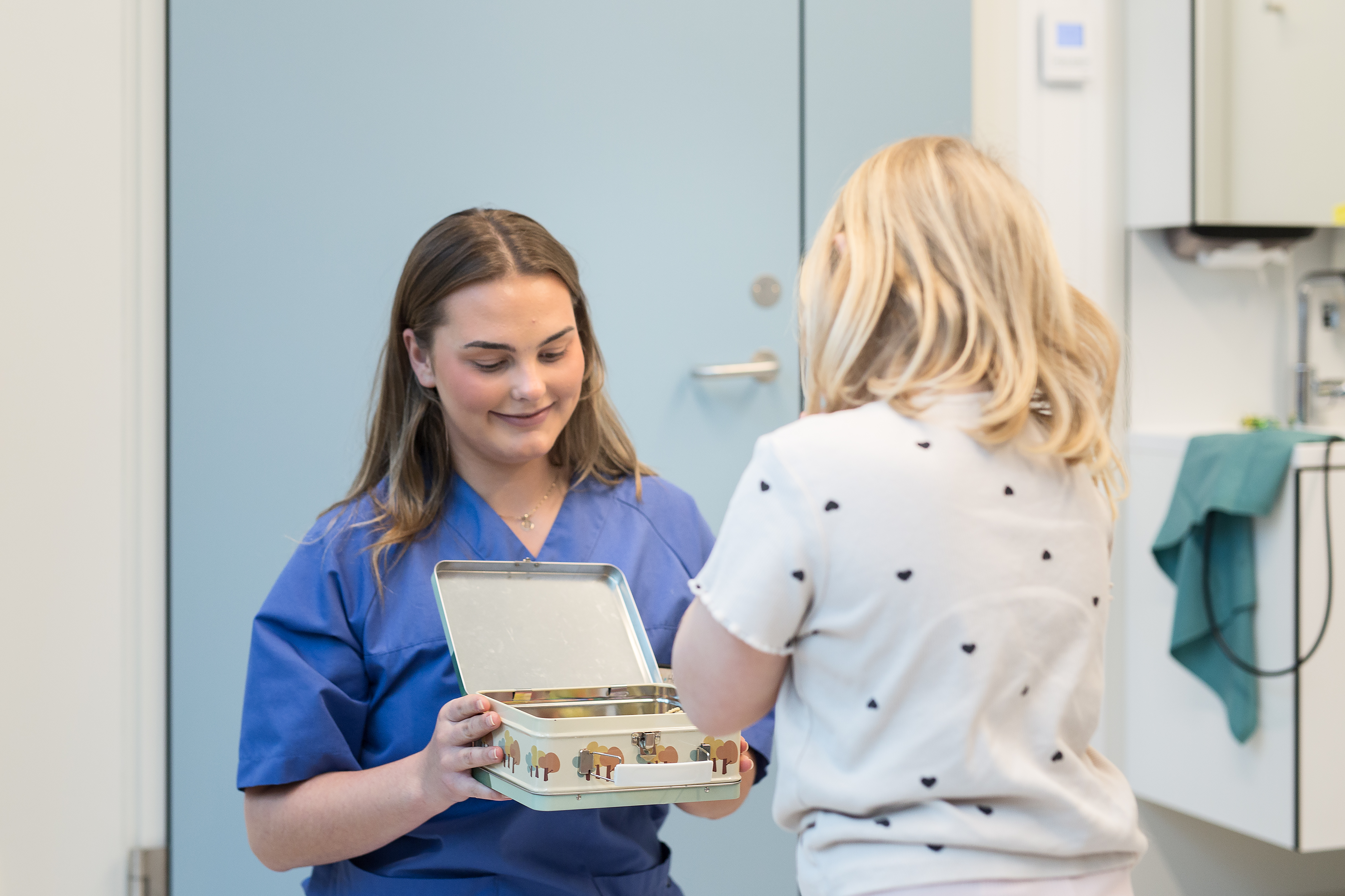 En dame som presenterer en eske for et barn