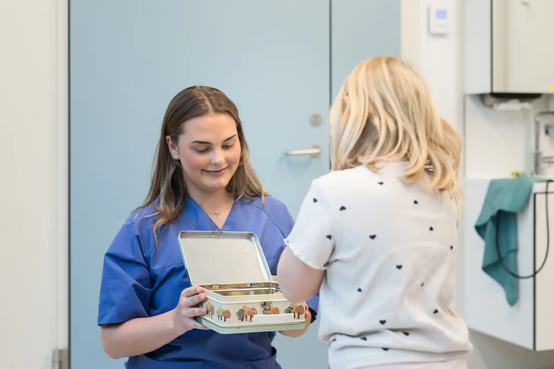 En dame som presenterer en eske for et barn