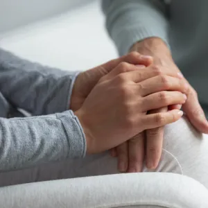 Et nærbilde av en person som holder hendene sammen