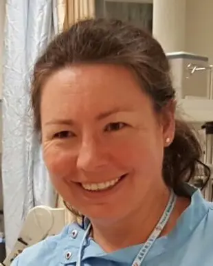 En kvinne som smiler til kameraet