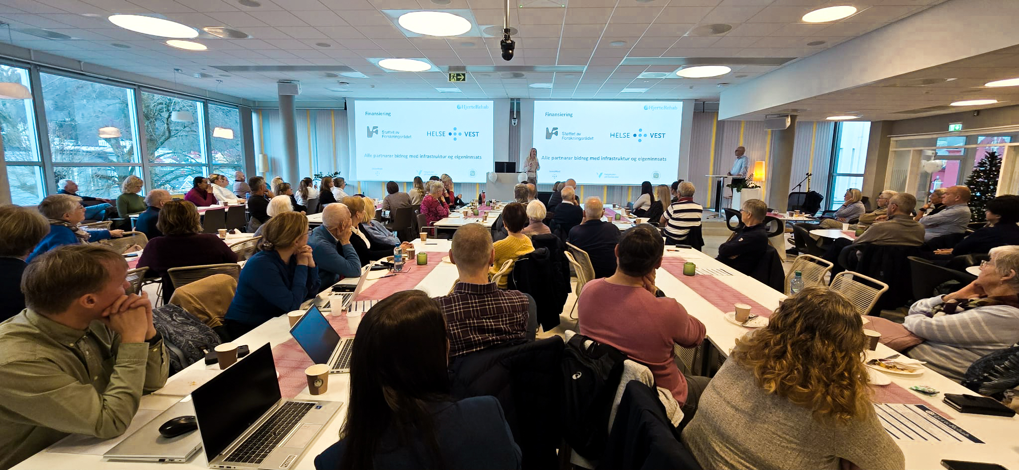 En gruppe mennesker som sitter i et rom med bærbare datamaskiner