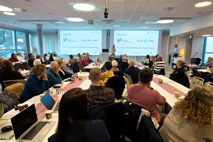 En gruppe mennesker som sitter i et rom med bærbare datamaskiner