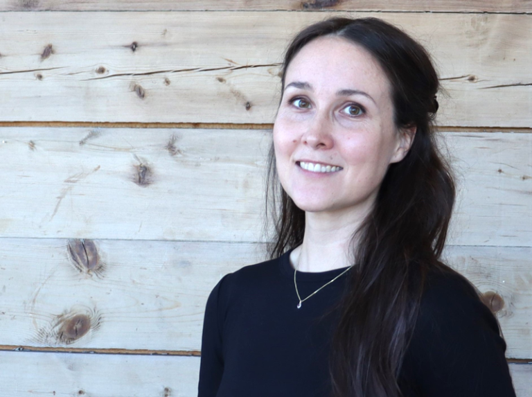 En kvinne som smiler til kameraet