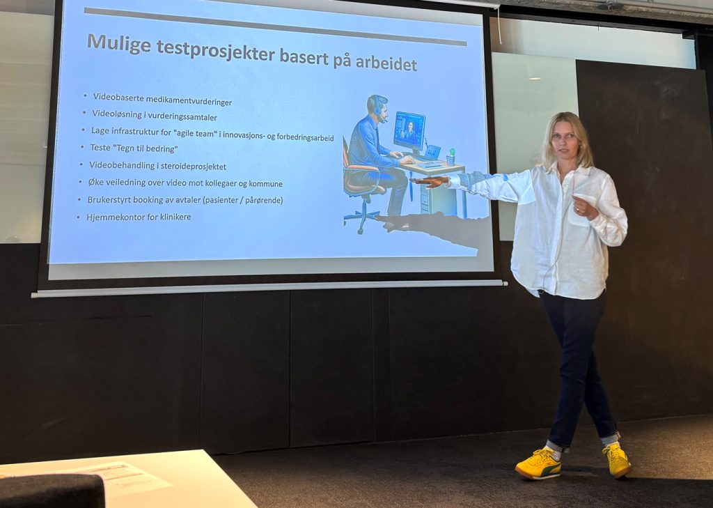 En person som står foran en stor skjerm