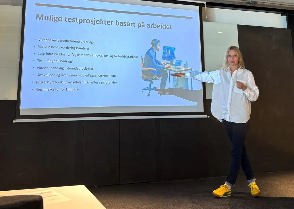 En person som står foran en stor skjerm