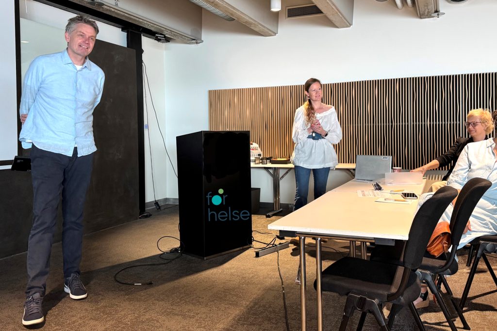 En mann og en kvinne som står i et rom med et bord og stoler