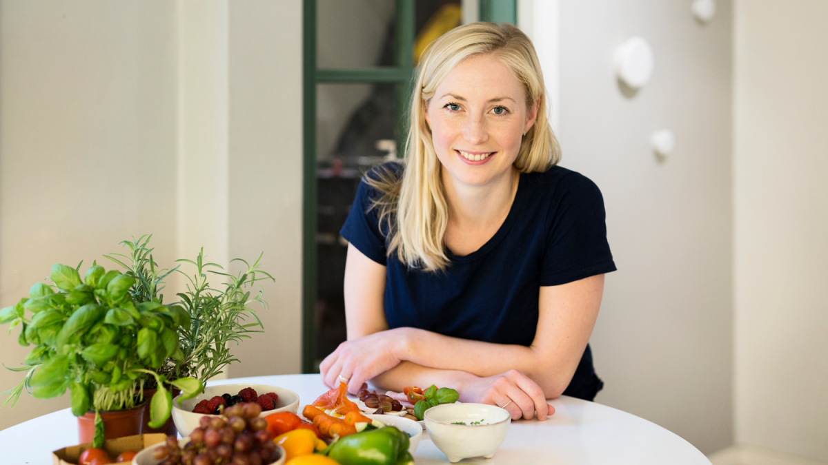 En kvinne som sitter ved et bord med mat