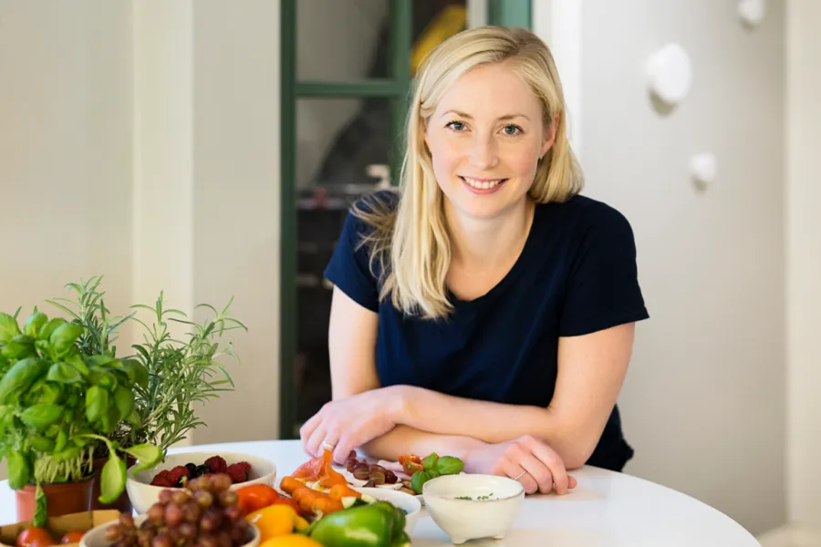 En kvinne som sitter ved et bord med mat