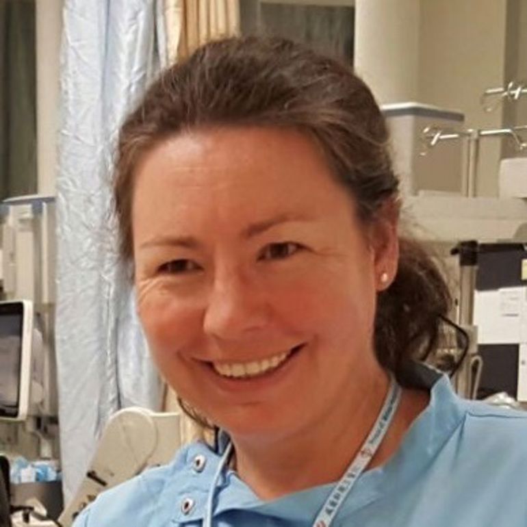 En kvinne som smiler til kameraet