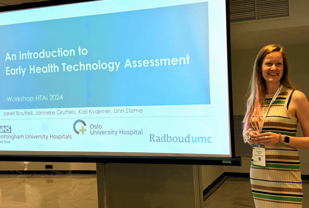 En kvinne som står ved siden av en skjerm