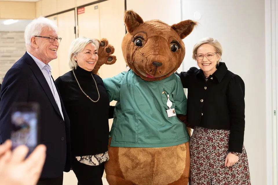 En gruppe mennesker som poserer med en person i et bjørneklær