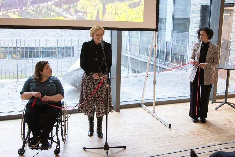 En gruppe kvinner som står i et rom med en person som sitter i en stol