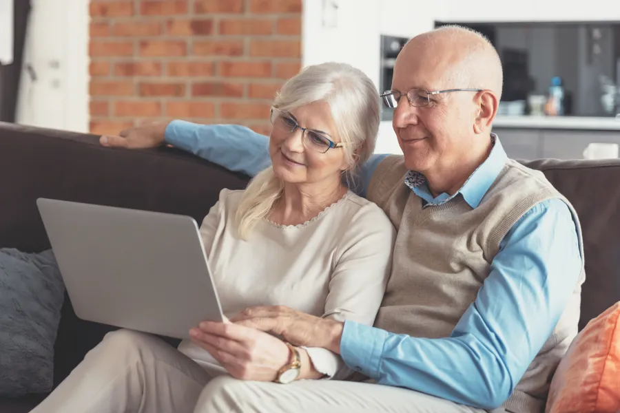 Eldre ektepar ser på PC
