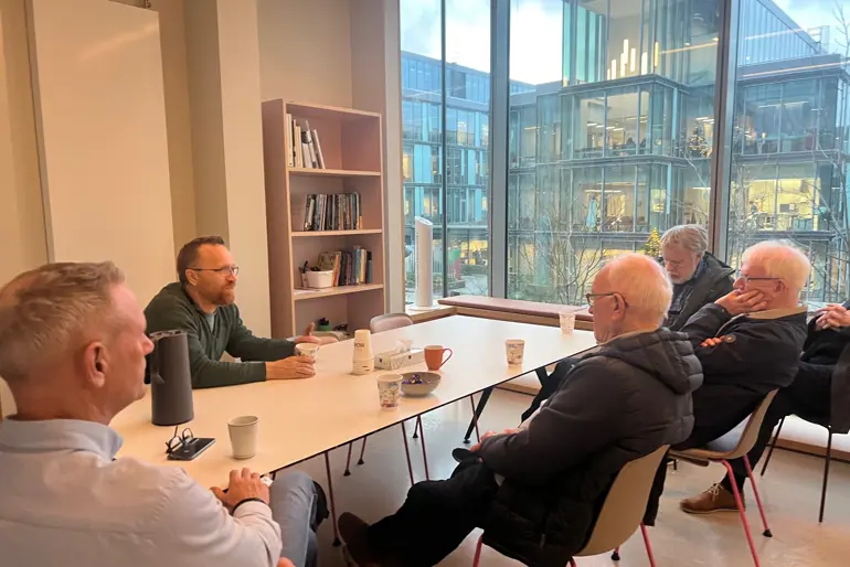 En gruppe menn som sitter rundt et bord