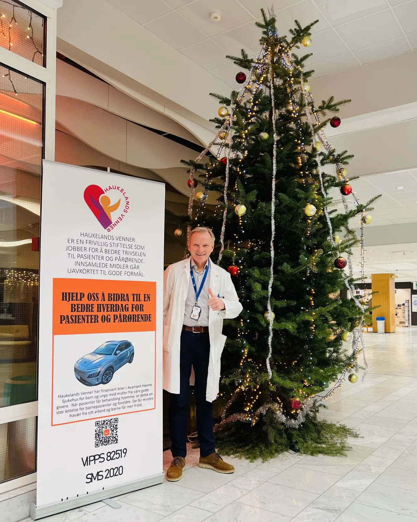 En person som står ved siden av et juletre