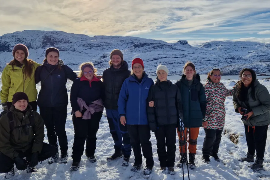 En gruppe mennesker som poserer for et bilde på et snødekt fjell